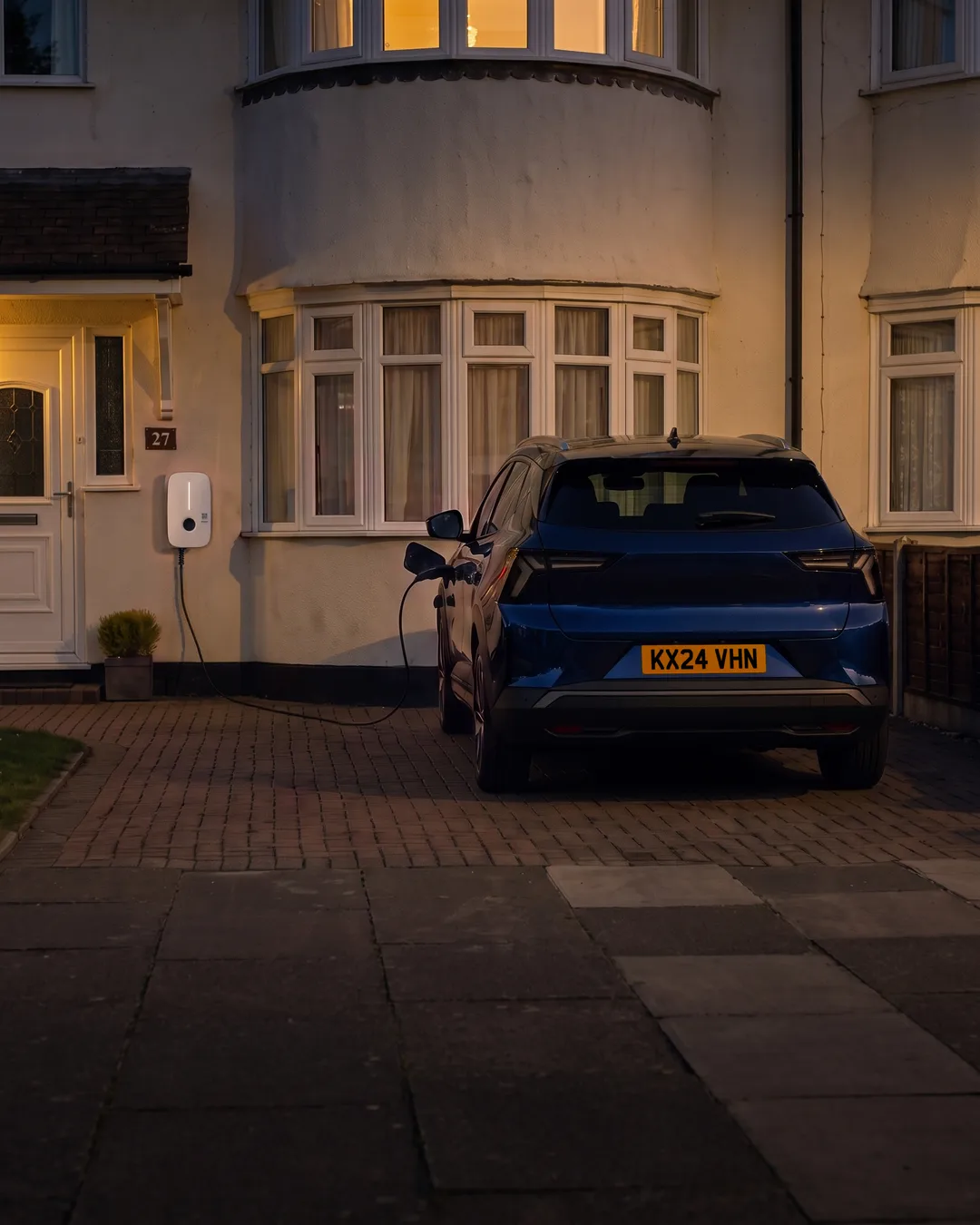 Night. Martin's own car plugged in on his drive.