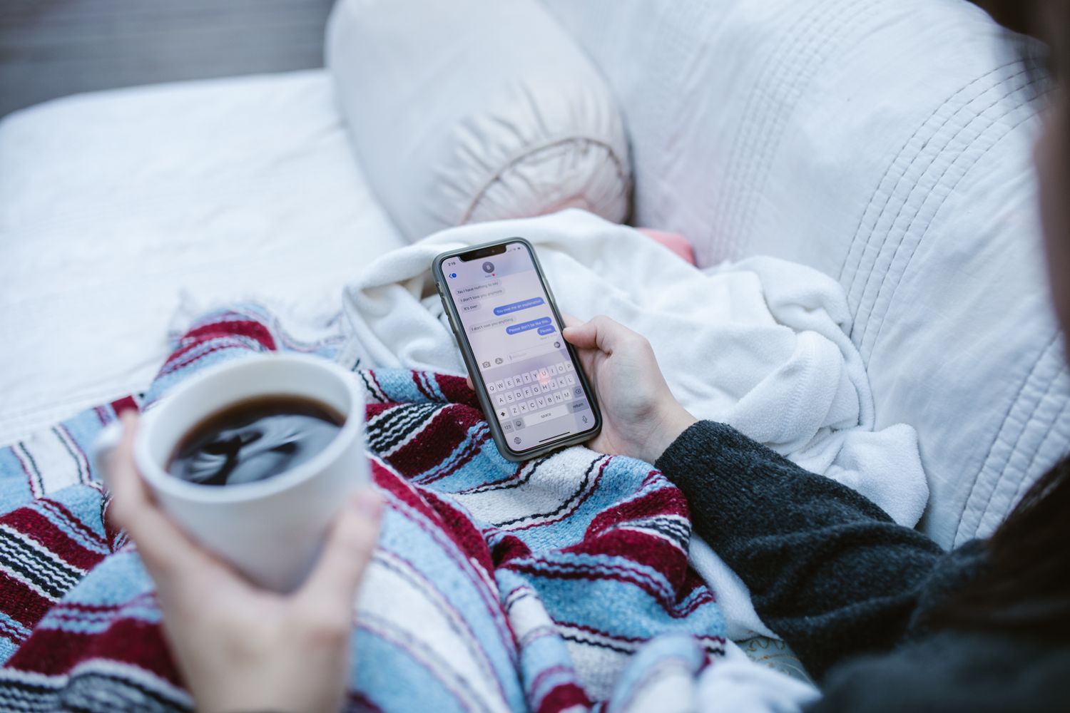Someone relaxed at home with a coffee and their phone