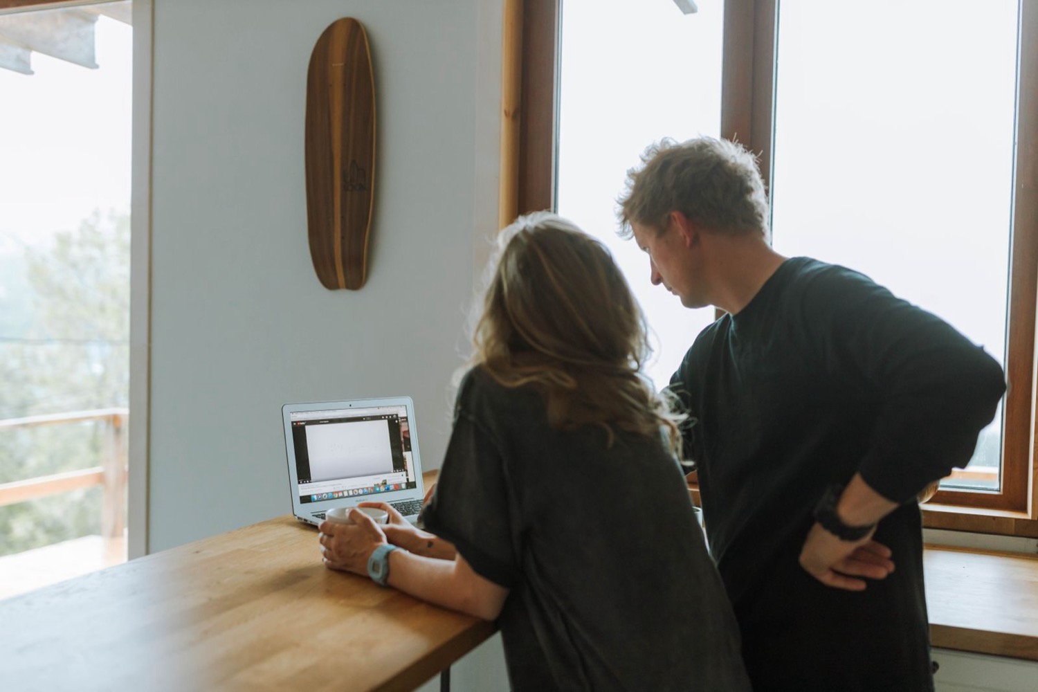 Two people building something together on a laptop at a kitchen counter
